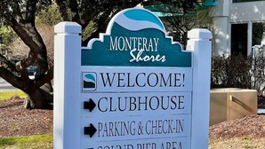 A sign for Monteray Shores with directions to the clubhouse, parking & check-in, and sound pier area. - Beach House (Corolla)