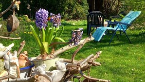 Ein Garten mit Rasenfläche, Stühlen und Dekoration.