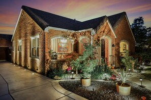 A brick house with a well-maintained garden and a visible front door.