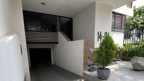 A modern residential building with a clean, minimalist design, featuring a concrete pathway, a small potted plant, and a visible number '14-04' on the wall. - Hotel 14-04 (Cali)