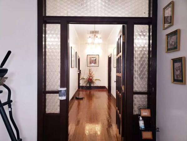 Stunning hallway with patterned wallpaper, framed artwork, and a beautiful vase of flowers.