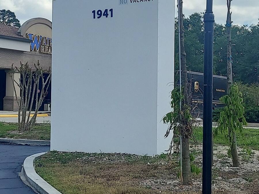 Señal de Hotel Blue con el año 1941 y un aviso de habitaciones disponibles.
