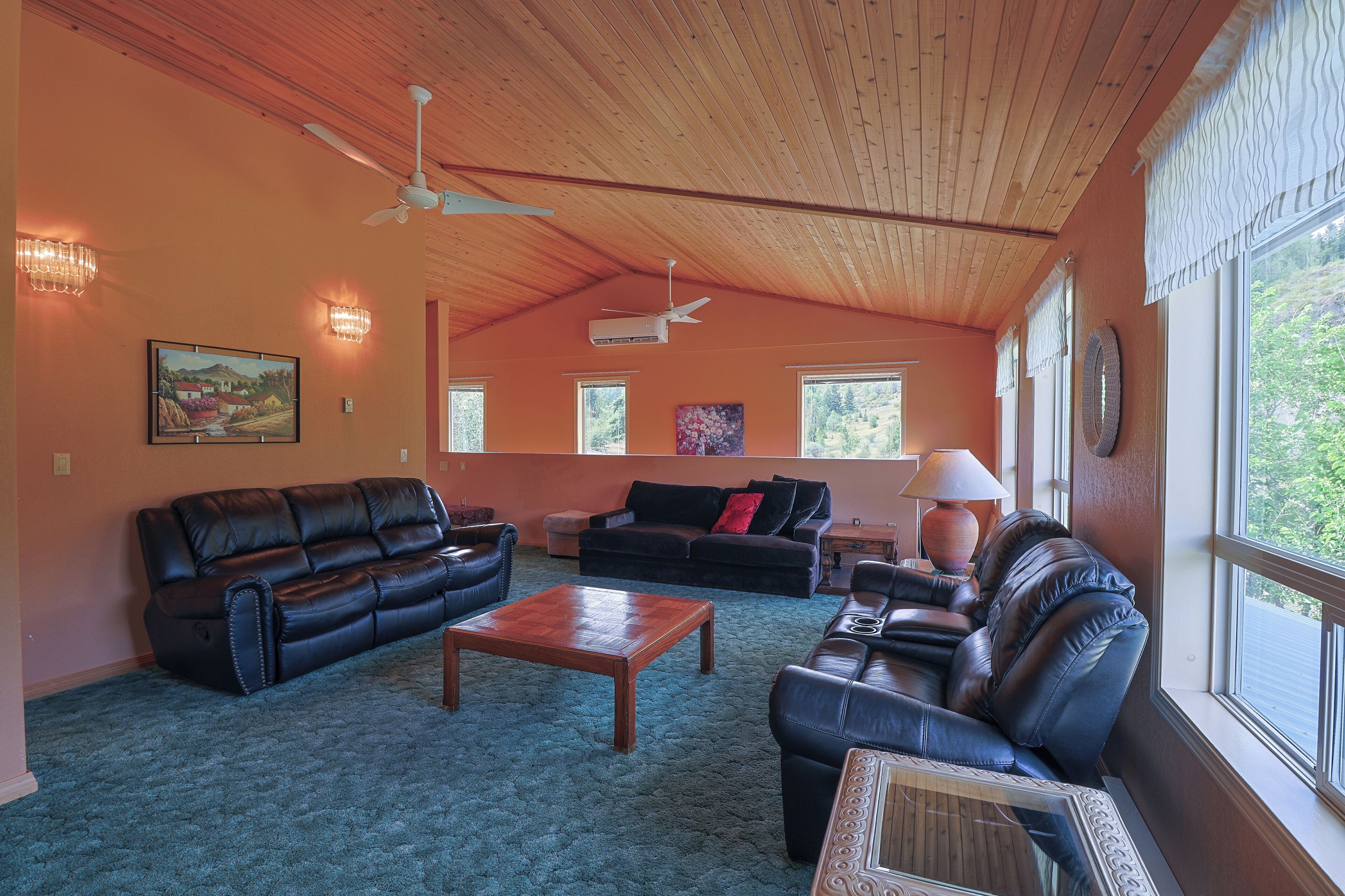 A living room with a wooden ceiling, two sofas, a coffee table, and a fireplace.