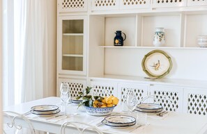 A dining table set with plates, glasses, and a bowl of lemons.