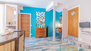 Une cuisine moderne avec un plan de travail en bois, une table en verre et un mur d’accent bleu.