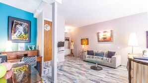 Un salon avec un mur d’accent bleu, un canapé, une table basse et un téléviseur.