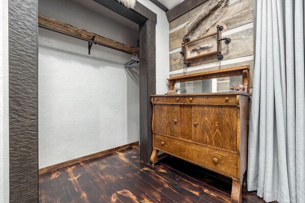 A room with a wooden cabinet, a coat rack, and a fur-covered wall.