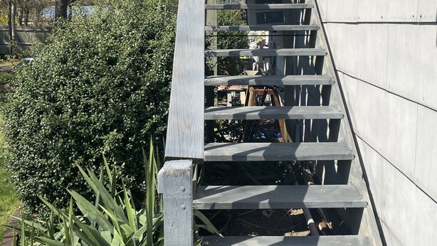 Un escalier extérieur en bois menant à un bâtiment.