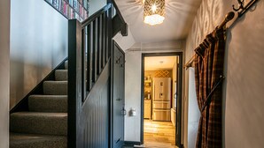 Una escalera conduce a una cocina con un refrigerador y una zona de comedor.