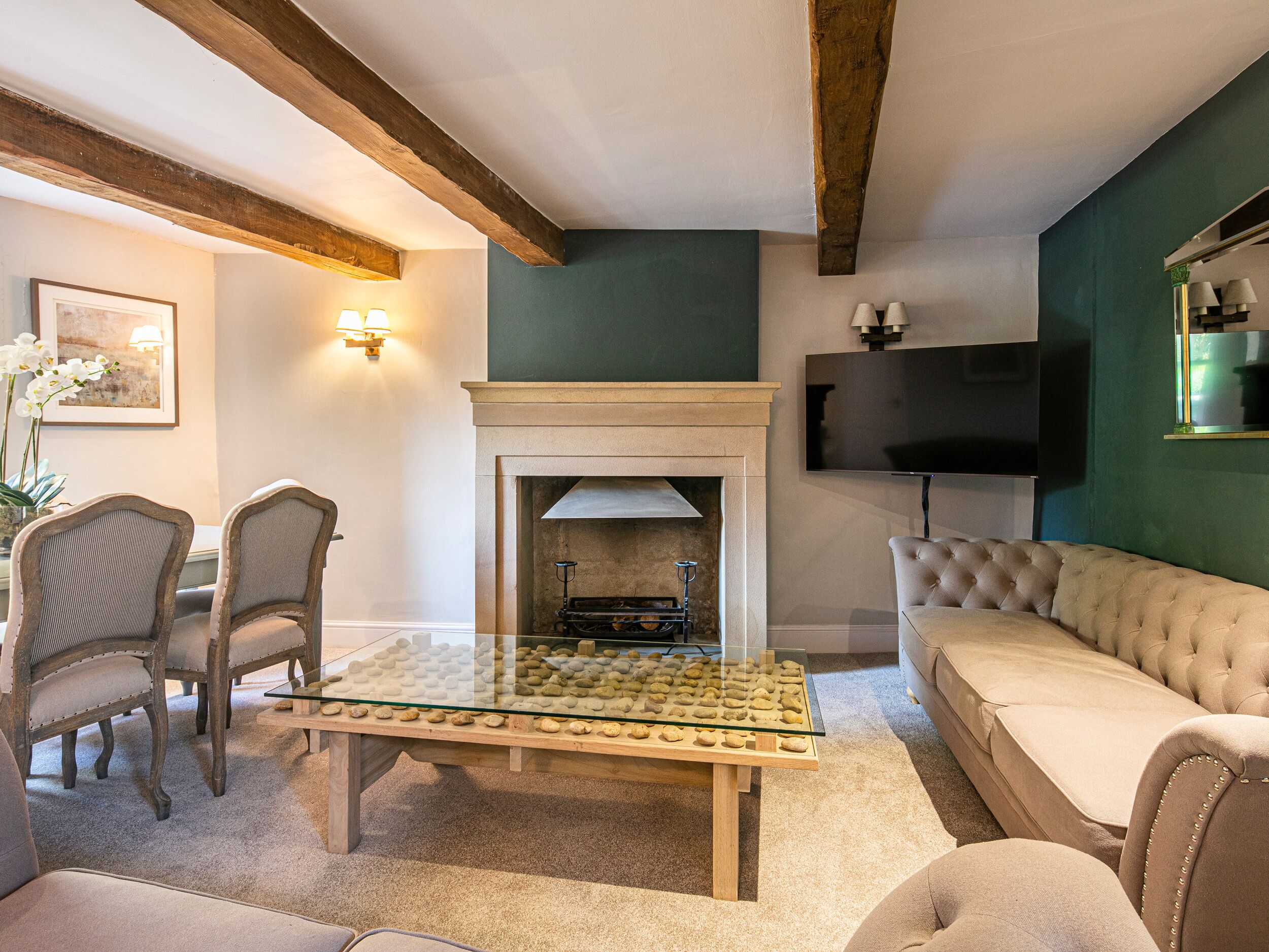 Una sala de estar con chimenea, una mesa de centro de vidrio y un sofá.