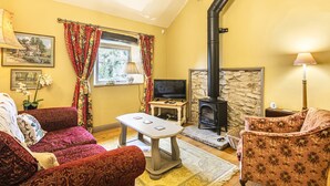 Una sala de estar acogedora con chimenea, televisor y asientos cómodos.