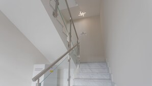 Un escalier avec des rampes en verre et une enseigne indiquant « ARC CAFÉ ».