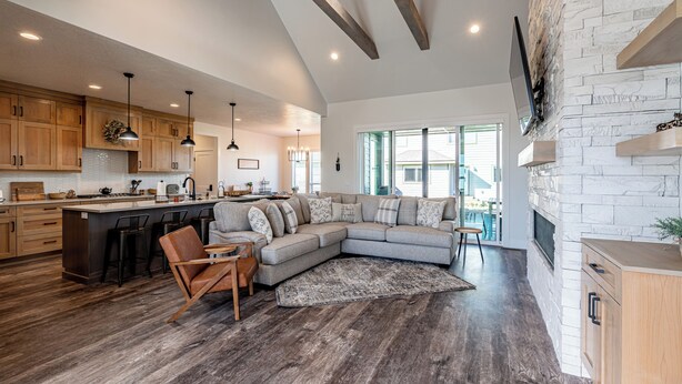 A spacious kitchen with wooden cabinets, a large island, and a dining area with a sofa and chairs.