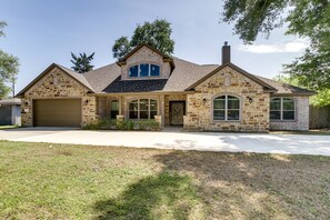 A two-story house with a stone facade, a garage, and a front yard.