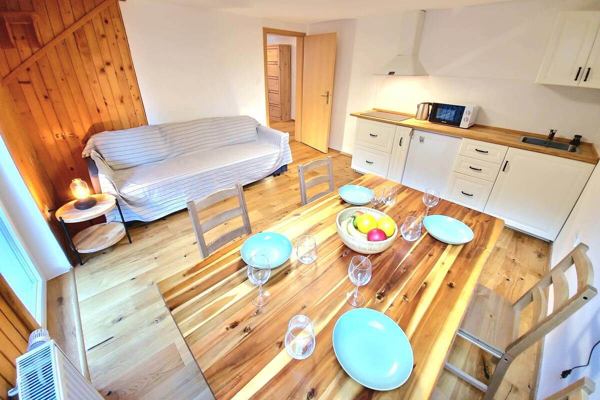 Cocina compacta con muebles de madera, un microondas y un lavamanos.
