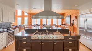 Een moderne keuken met een centraal eiland, een fornuis en een koelkast.