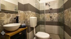 A bathroom with a large white sink, a toilet, a shower with a glass door, and a mirror above the sink. - Aida Guest House (Nazareth)