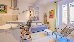 A modern kitchen with a built-in island, bar stools, a sofa, and a dining table. - Le Pêcheur Revisité by Winkyhouse Cassis (Cassis)