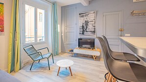 A modern living room with a TV, a sofa, a small table, and a chair. - Le Pêcheur Revisité by Winkyhouse Cassis (Cassis)
