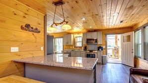 Une cuisine spacieuse dotée de plans de travail en granit, d’armoires en bois et d’un îlot central.