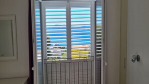 A room with a sliding glass door featuring horizontal blinds, a small balcony with a metal railing, and a white door with a handle. - Holiday Home Mico with Swimming Pool (Drvenik)
