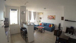 Ein modernes Apartment mit Küche, Essbereich und Wohnzimmer.