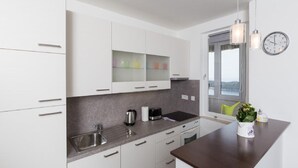 Eine moderne Küche mit weißen Schränken, einer dunklen Arbeitsplatte, einem Spülbecken und einem Fenster mit Blick.