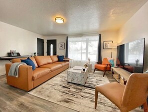 Relax in this stylish living room with a leather sofa, armchair, and coffee table, perfect for unwinding.
