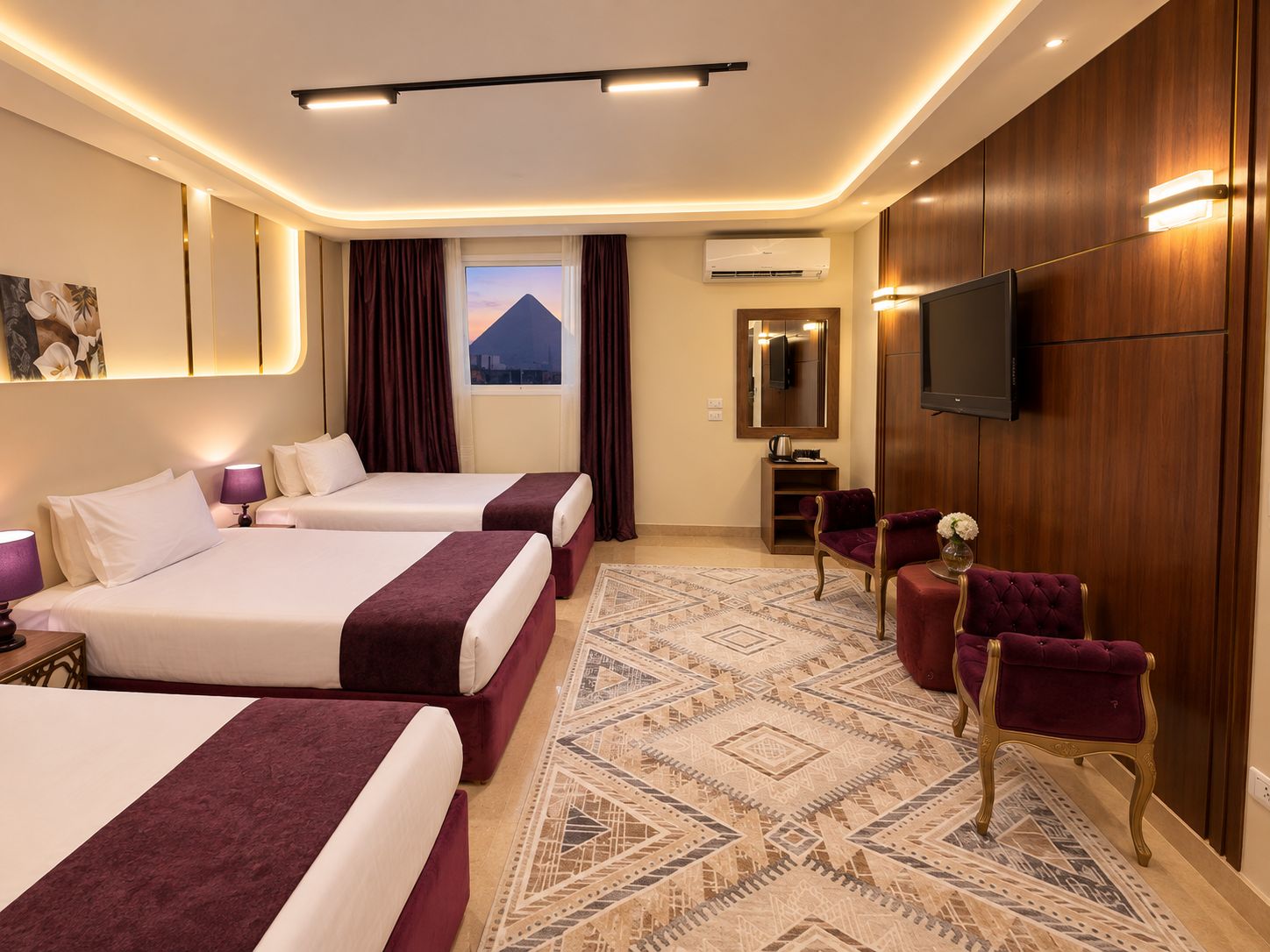 Habitación de hotel con dos camas, un espejo grande, un televisor de pantalla plana y vista a la montaña desde la ventana.