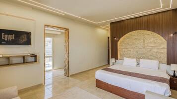 A modern bedroom with a large bed, a stone accent wall, a mounted artwork, and a wooden panel wall.