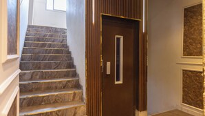 A staircase with marble steps leading to a wooden door with a small window. - King Cheops Inn (Giza)