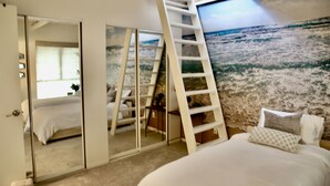 A bedroom with a bed, a ladder, a large window, and a mural of a beach scene. - Quiet Townhome with Ocean View (Solana Beach)