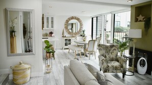 A modern living room with a dining area, large windows, and a view of the outdoors. - Quiet Townhome with Ocean View (Solana Beach)