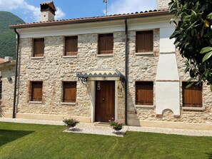 A stone building with multiple windows and a central entrance. - Midas & Lino's house holiday home<br> (Solagna)