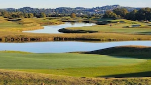 A golf course with multiple ponds and a distant town. - The Great Escape, King suite, Kid friendly (Sevierville)