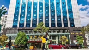 A modern building with a glass facade and multiple floors. - Jindu Hotel (Longnan)