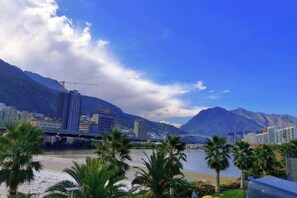 A coastal cityscape with mountains, a river, and a bridge. - Jindu Hotel (Longnan)