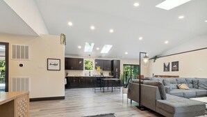 A spacious living area with a grey sectional sofa, a wooden cabinet, and a kitchen in the background. - Emerald in Berkeley Springs, WV (Berkeley Springs)