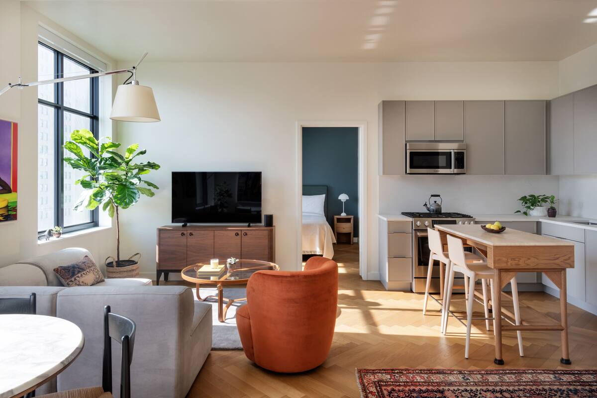 A modern apartment with a living room, dining area, and kitchen.