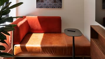 A modern living room with a red sofa, a small round table, and a television.
