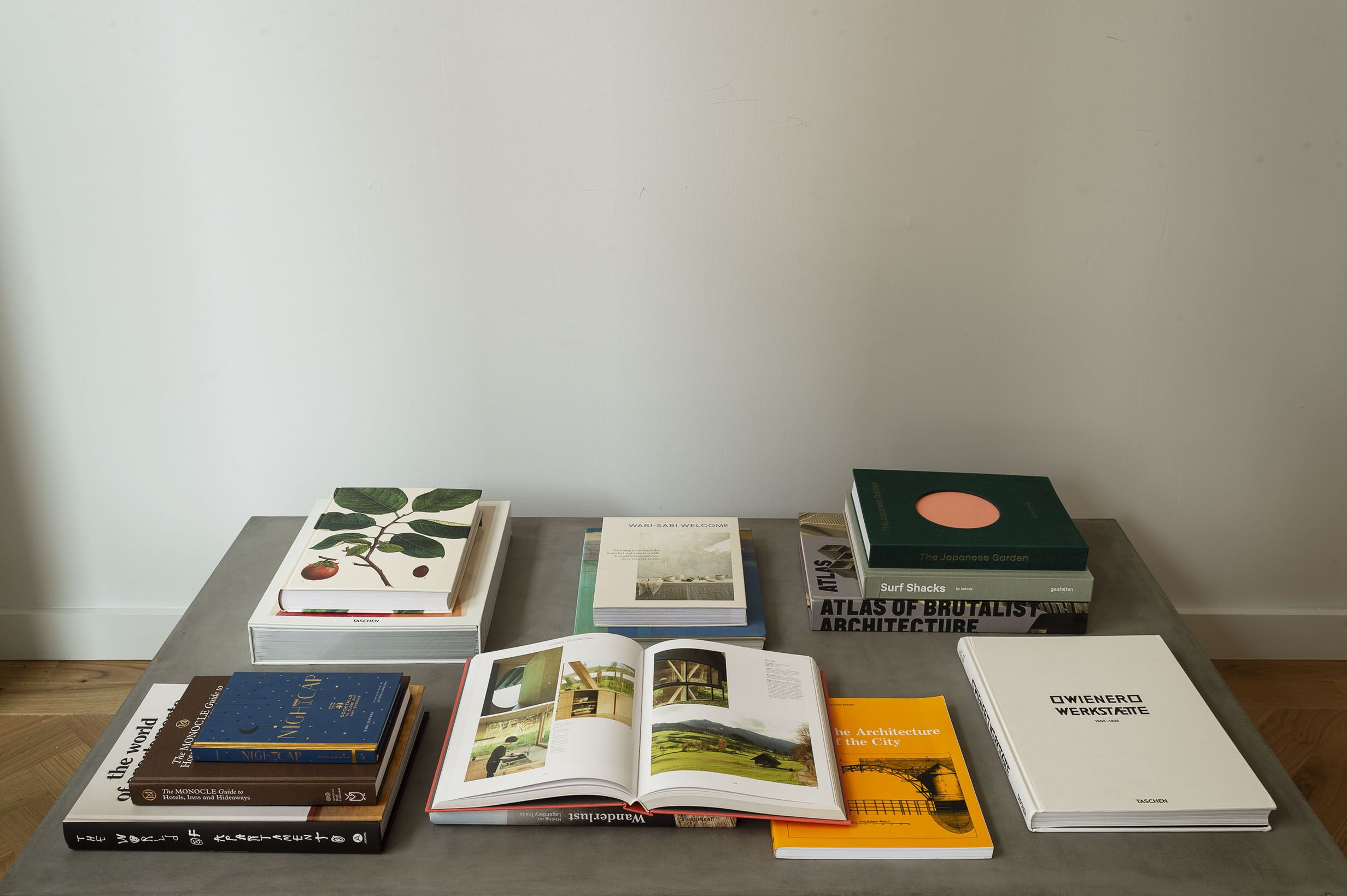 A table with various books and a magazine, including titles like "The Japanese Garden" and "Atlas of Brutalist Architecture".