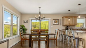 Una cocina amplia con comedor, ventanas grandes y vista a zonas verdes.
