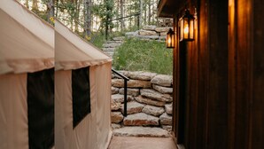 A stone staircase leading to a wooden building with a tent on the left.