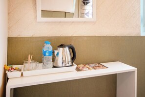 A hotel reception desk with a water bottle, a kettle, and a tray with brochures. - Villa Khufu Pyramids Hotel (Giza)