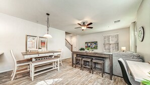 Une cuisine moderne avec un coin repas, un plancher en bois et un ventilateur de plafond.