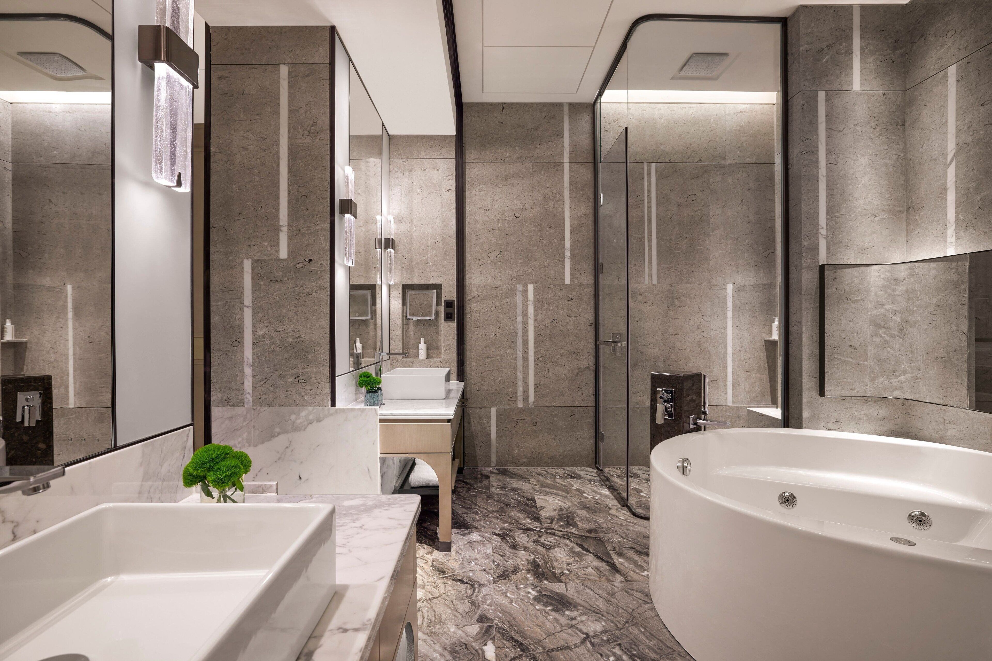 Un baño moderno con una bañera grande, zona de ducha y tocador con espejo.