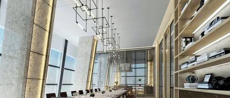 Uma sala de jantar moderna com uma mesa comprida, cadeiras e iluminação pendente.