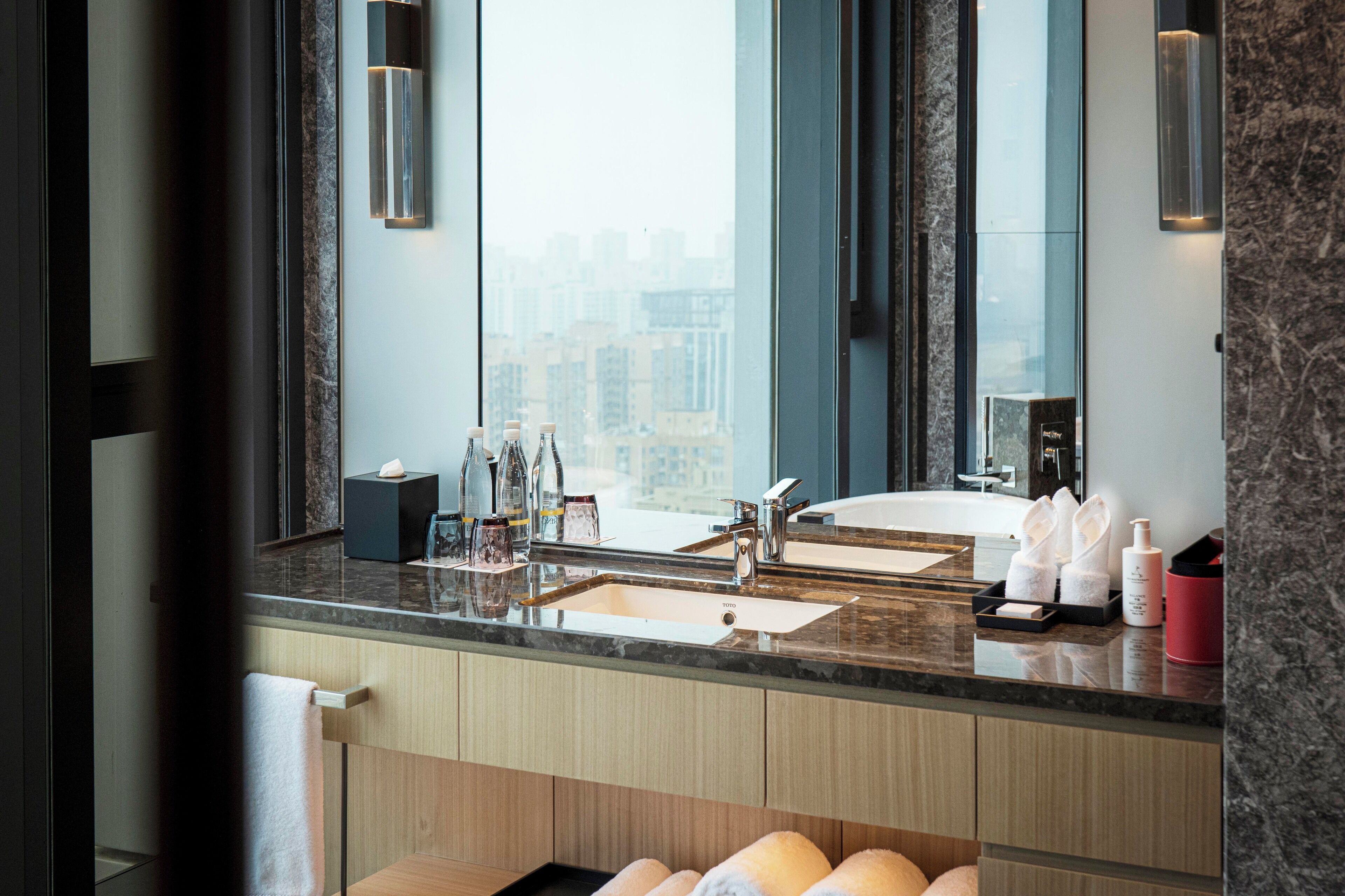 A modern bathroom with a large mirror, two sinks, and a vanity.