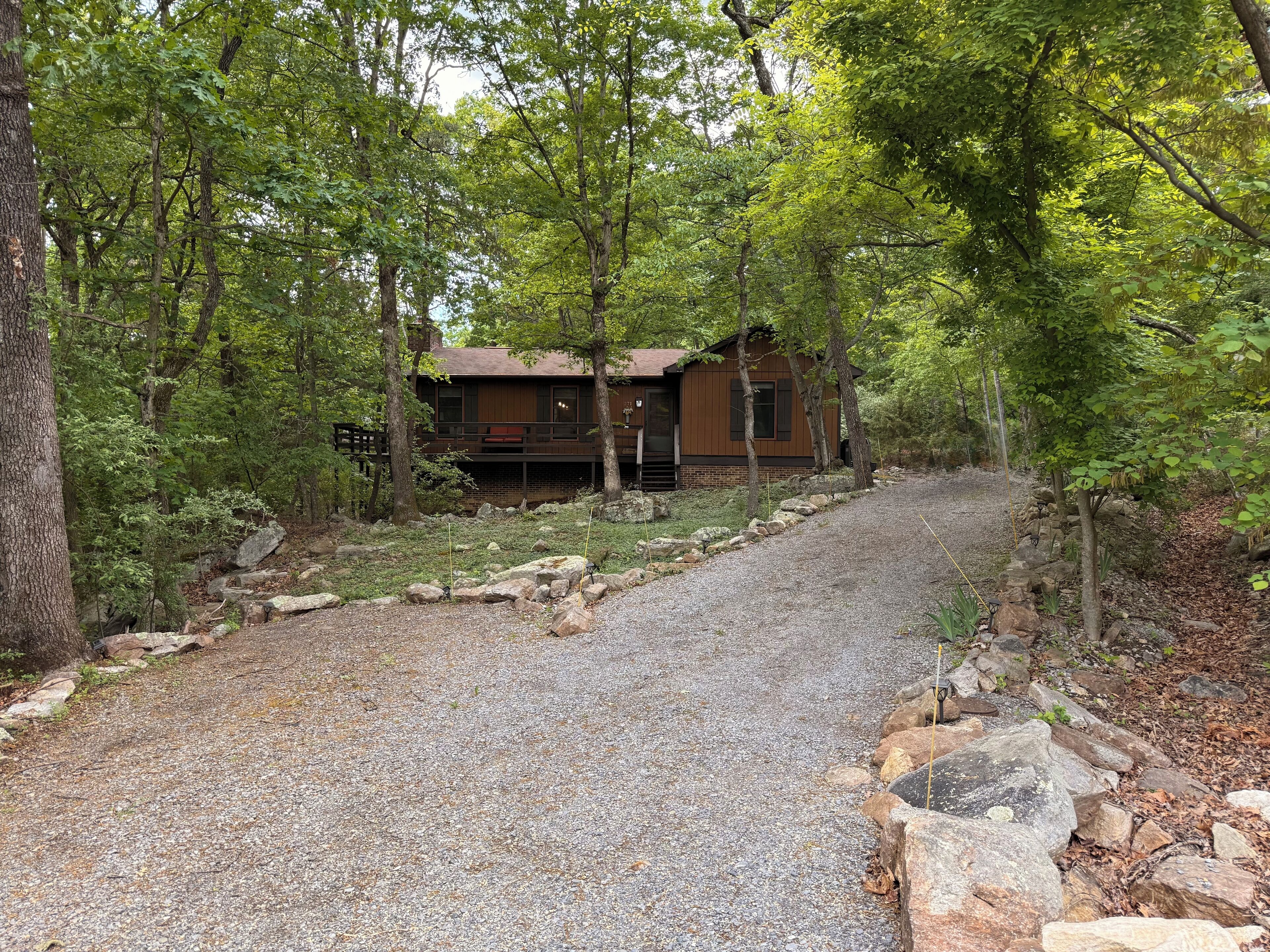 Une cabane avec une allée en gravier menant à une terrasse en bois.