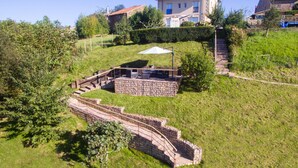 A stone structure with a staircase leading up to a building. - Apartamentos Corona (Comillas)